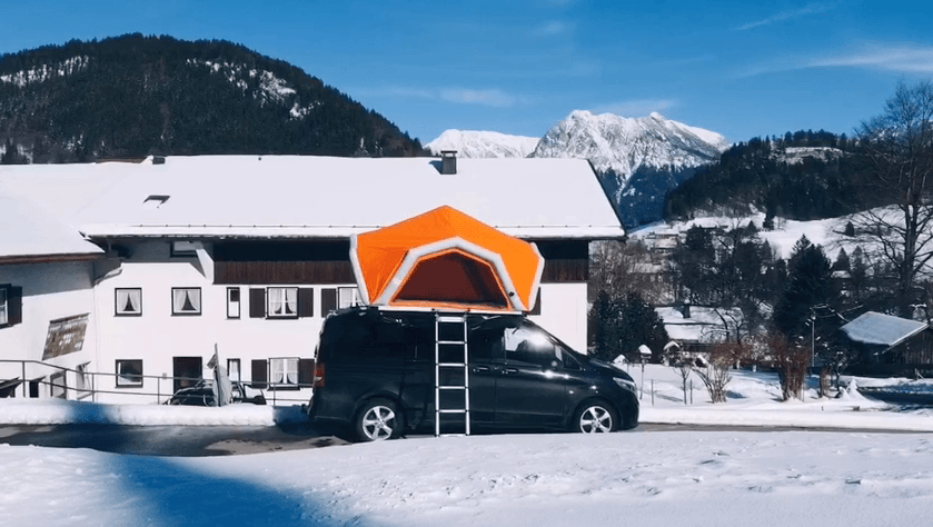 Fjordsen's bright-orange tent stands out against the snowy backdrop