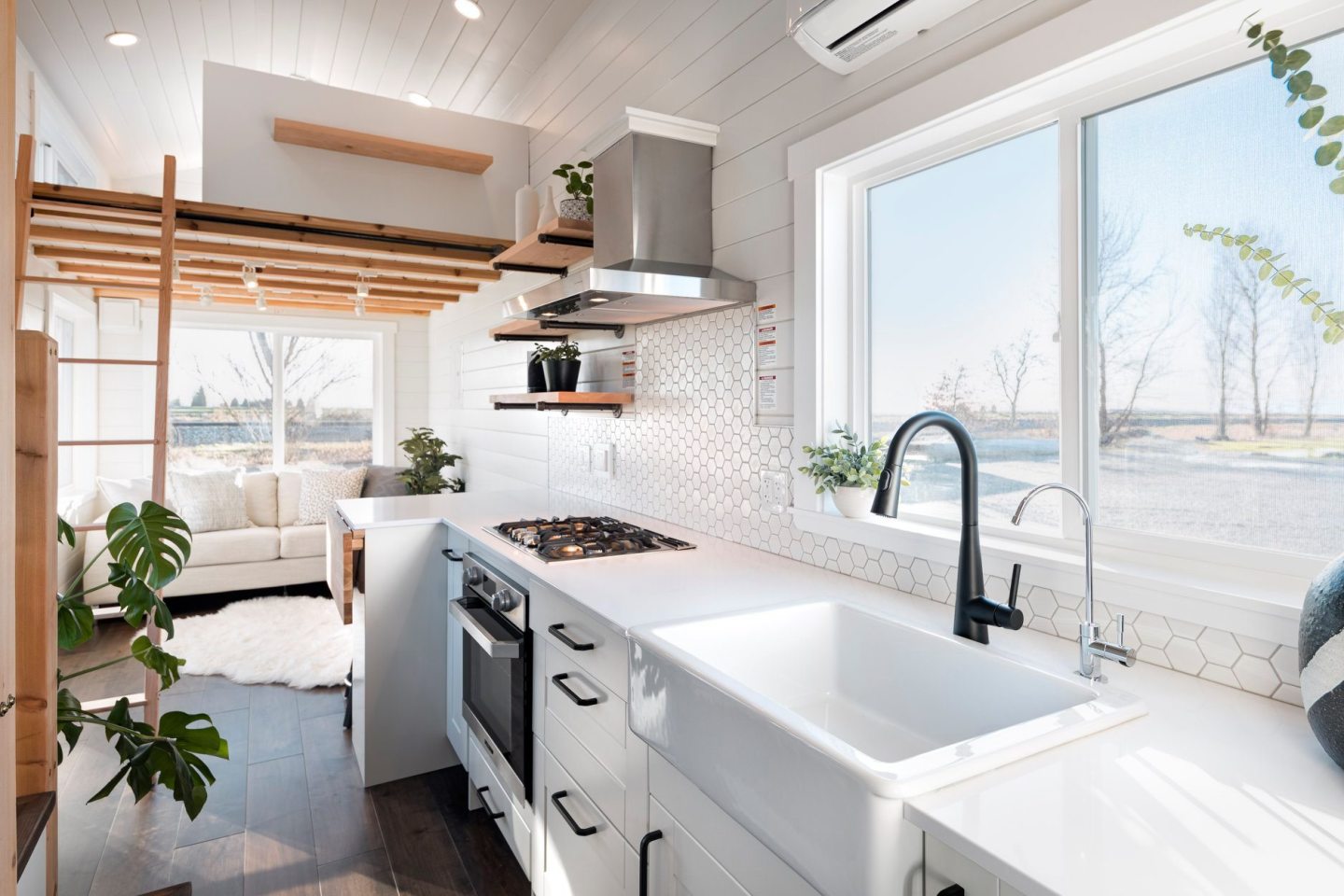 The 34ft Eco-Friendly Tiny House RV's kitchen includes a farmhouse-style sink