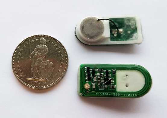 The prototype of the device, next to a Swiss Franc coin for comparison. The chamber of beta cells can be seen at the top, with the electronics that control them seen on the bottom