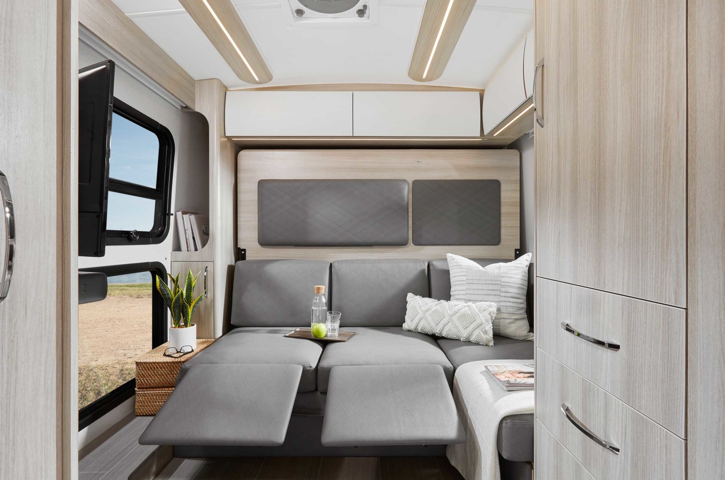 The rear lounge includes an L-shaped sofa with two recliners