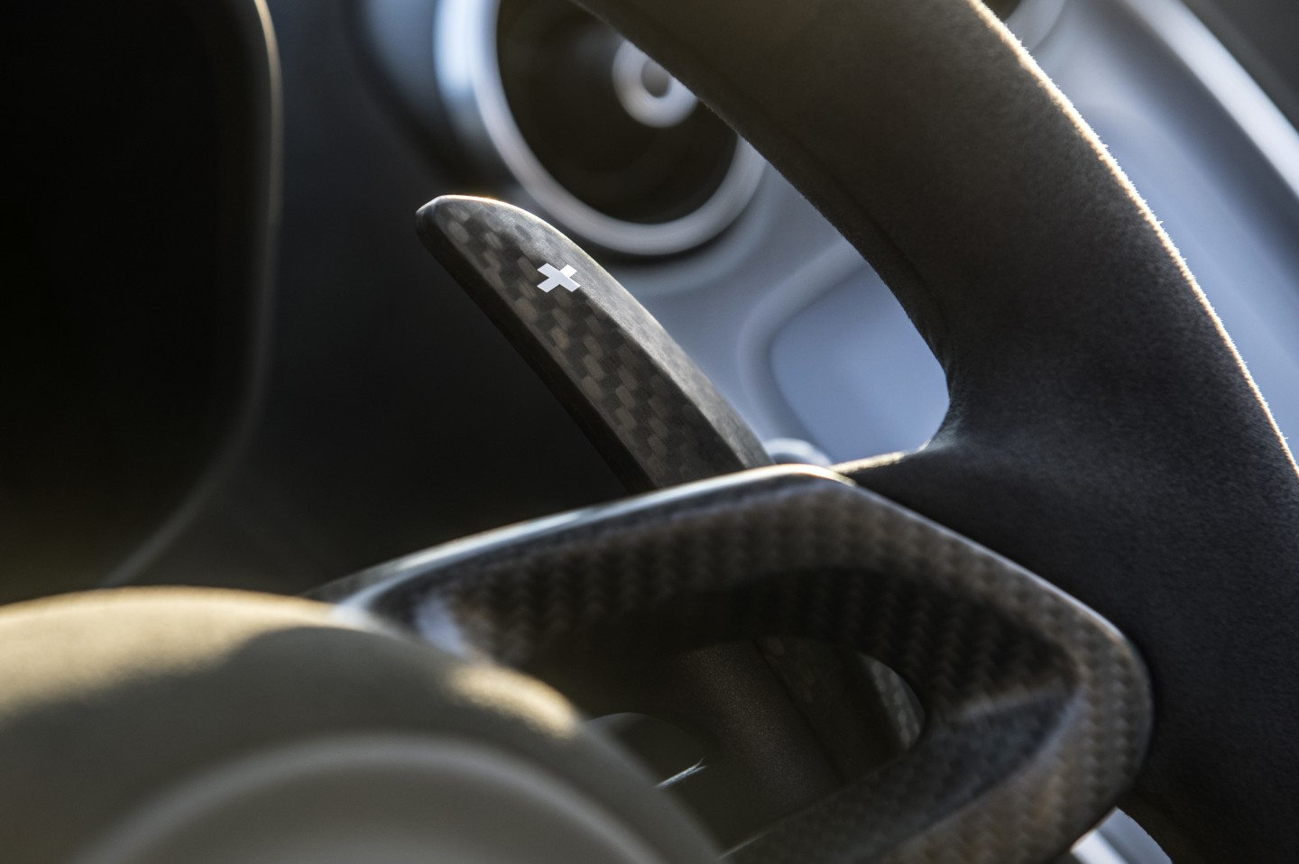 The integrated fiber paddle shifters on the McLaren's steering wheel are on a rocker, allowing up and down shifts to be made one-handed