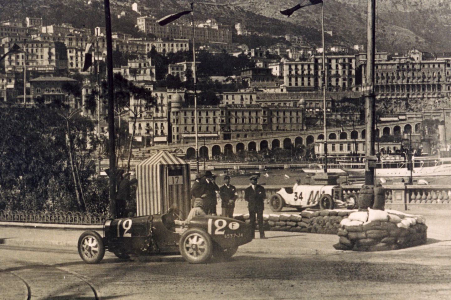 The first Monaco Grand Prix in 1929 saw Bugatti lock out the front row and qualify 1, 2, 3, 5, and 6th making up more than half the cars in the race and storming the results, finishing 1, 2, 4, 5, 6, and 7th, with only the Mercedes-Benz “works” SSK preventing a clean sweep. Pictured is the winner, British driver William Grover-Williams, one of those British larger-than-life characters who subsequently turned out to be a real-life “James Bond.” It turned out that Grover-Williams secretly worked for British Military Intelligence and during World War II would be captured, identified as the head of a major spy network and executed by the Nazis.