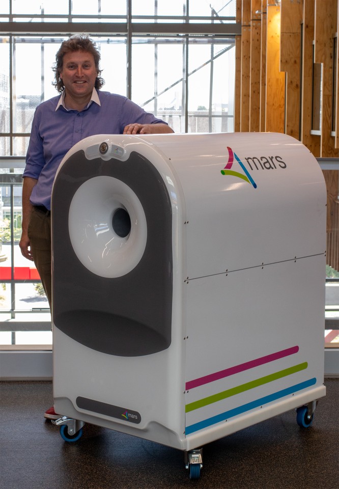 MBI's Chief Medical Officer Anthony Butler stands next to the 3D scanner in its current form