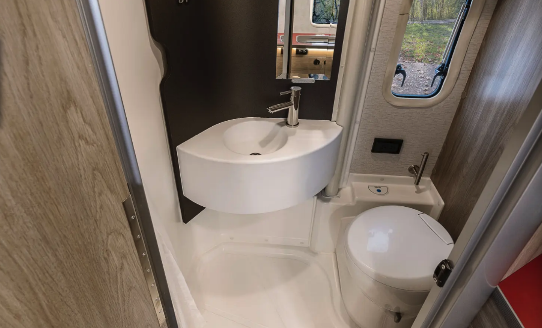 The clever bathroom uses a swiveling sink wall for "toilet" and "shower" modes; in toilet mode, the cassette toilet swivels to face the shower, providing the legroom needed to sit down