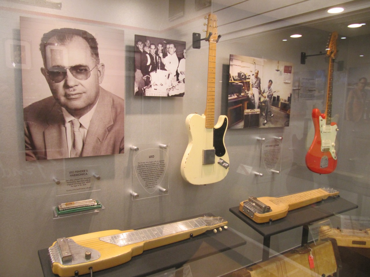 Photo of Leo Fender, along with some early guitar models on show at the Fender Guitar Factory Museum