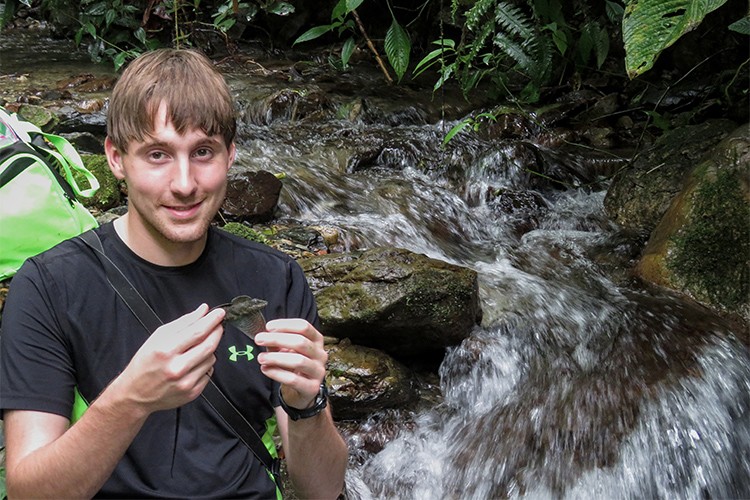 Recent master of science graduate Chris Boccia with a semi-aquatic anole
