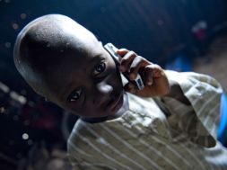 Young child listens on a mobile telephone