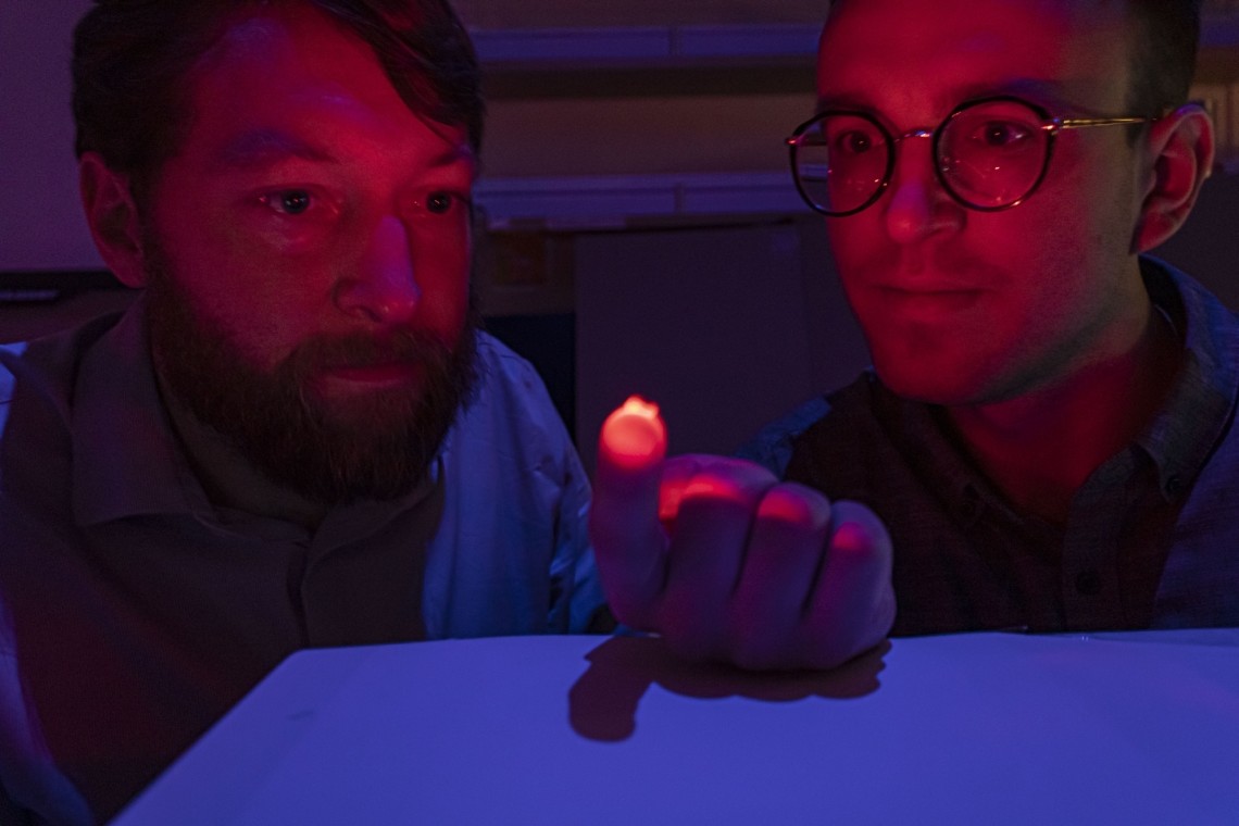 Philipp Gutruf (left) and Jokubas Ausra demonstrate how the device is able to transmit light through biological tissue