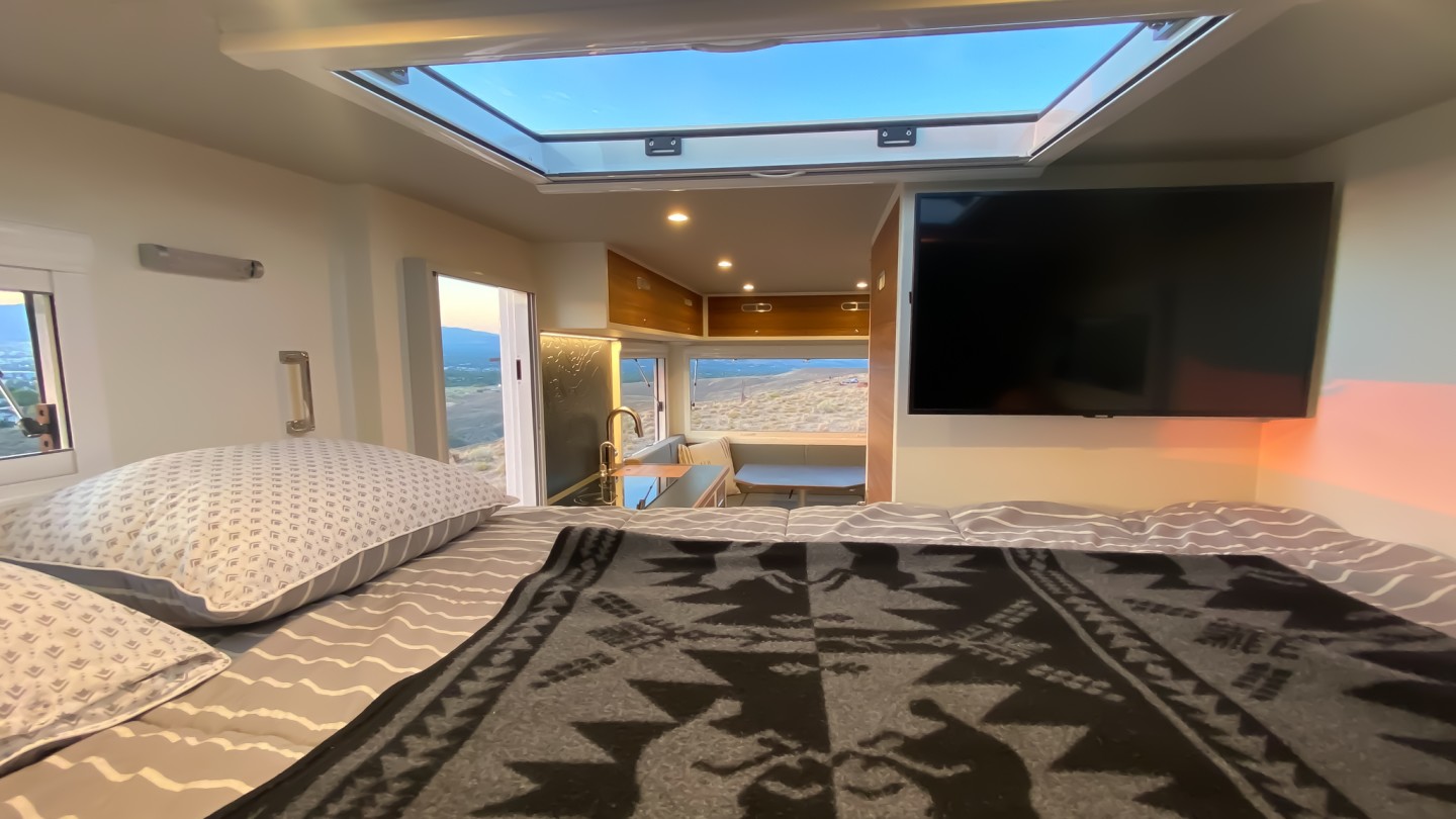 TruckHouse creates a cozy alcove bedroom with overhead skylight and available 32-in TV an