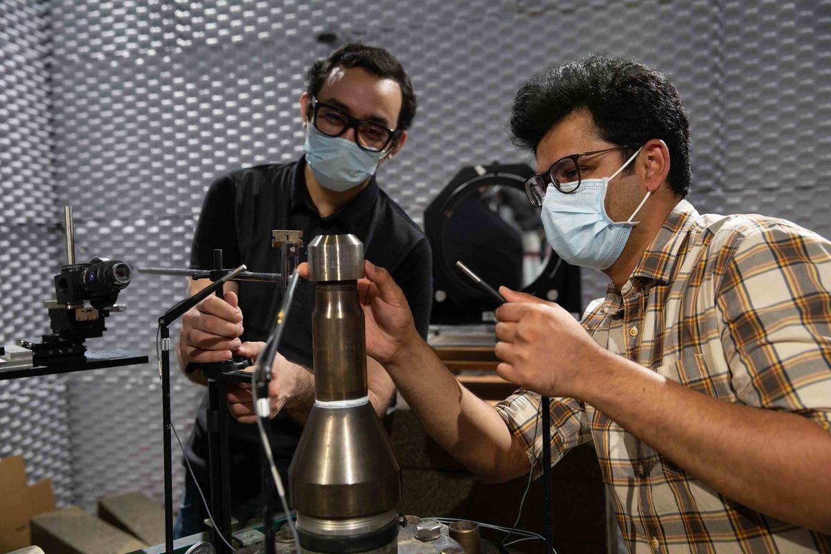 Doctoral students Mohammad Saleem and Aatresh Karnam work with a scale-model jet engine