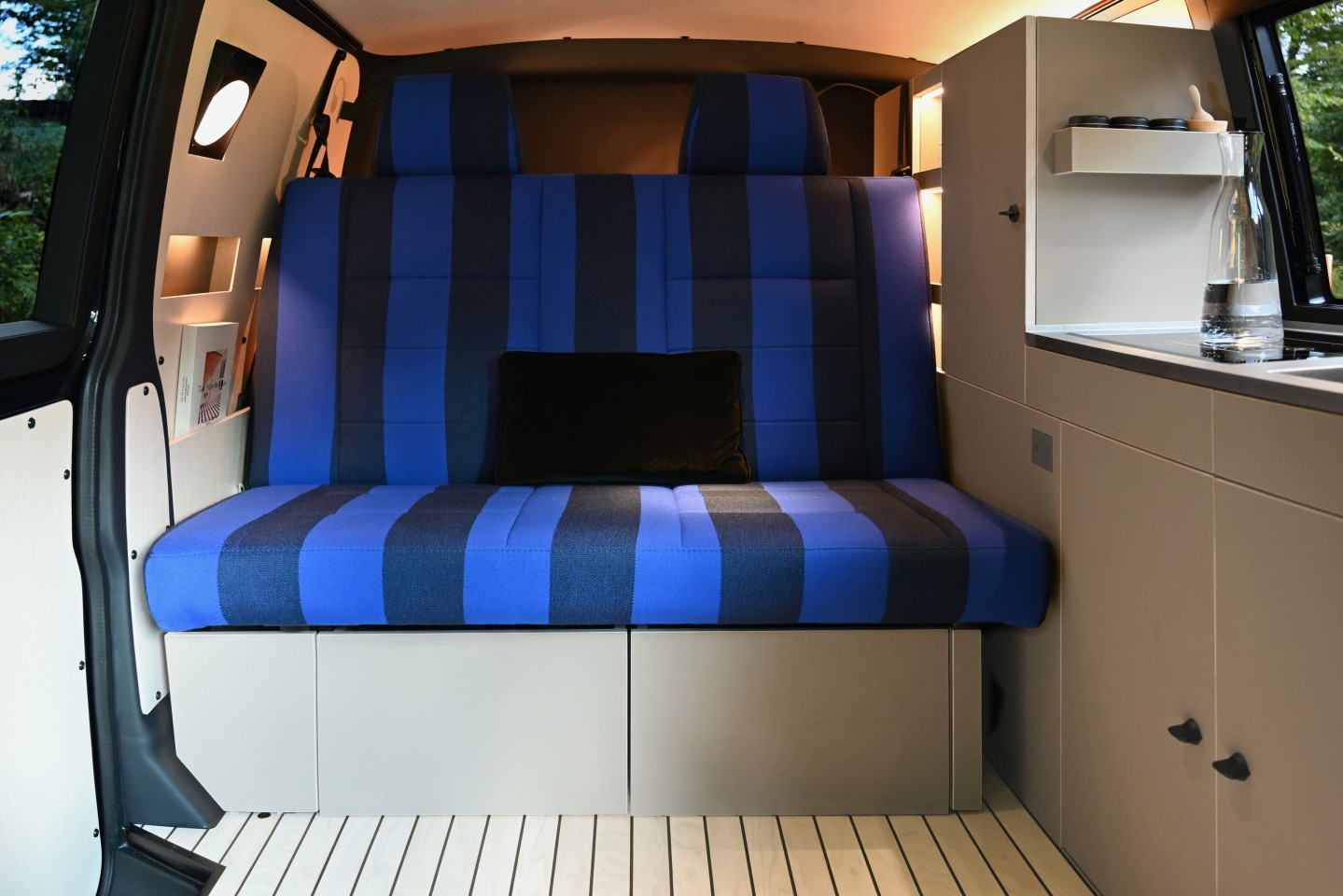 The sleeping bench features an iconic stripe design by Raf Simons, offering a nautical feel to the camper