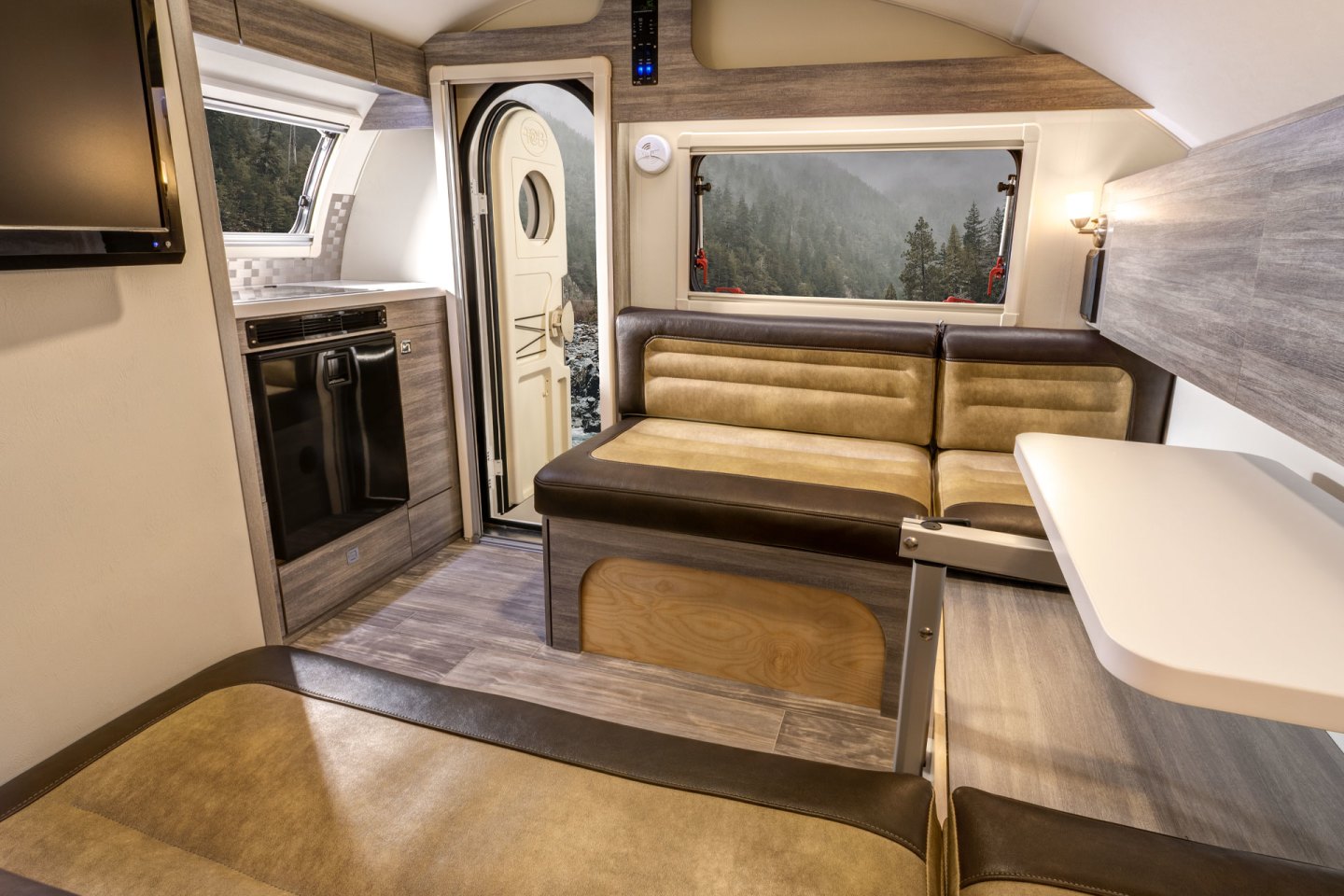 A convertible dinette inside the Ultimate Camper folds up into a queen-size bed for two