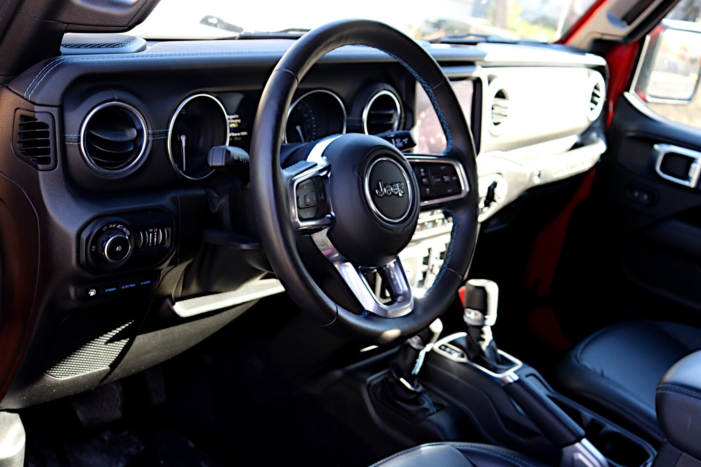Outside of the EV/Hybrid/EV Saver buttons in blue (bottom left) and a gauge in the cluster showing battery life and estimated EV range, the Wrangler 4xe is