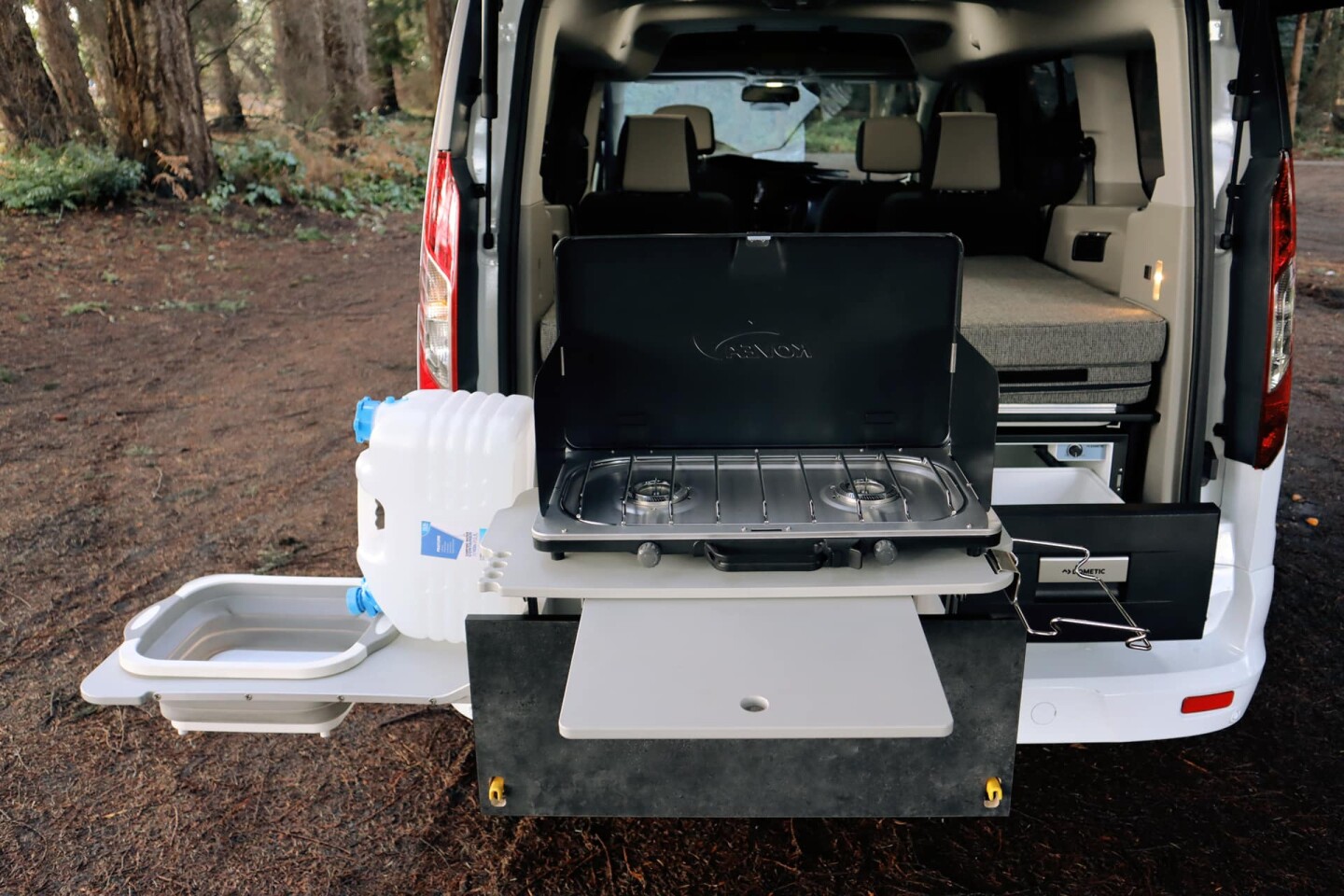 Caravan Outfitter's new kitchen design includes a dual-burner stove, expandable worktop, drawer fridge, and collapsible sink basin with water canister