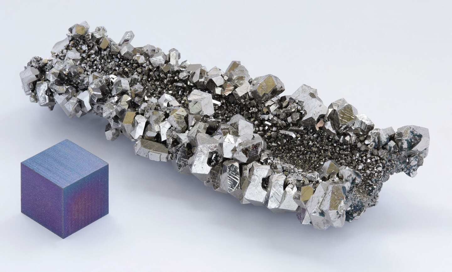 Niobium crystals next to an anodized niobium cube