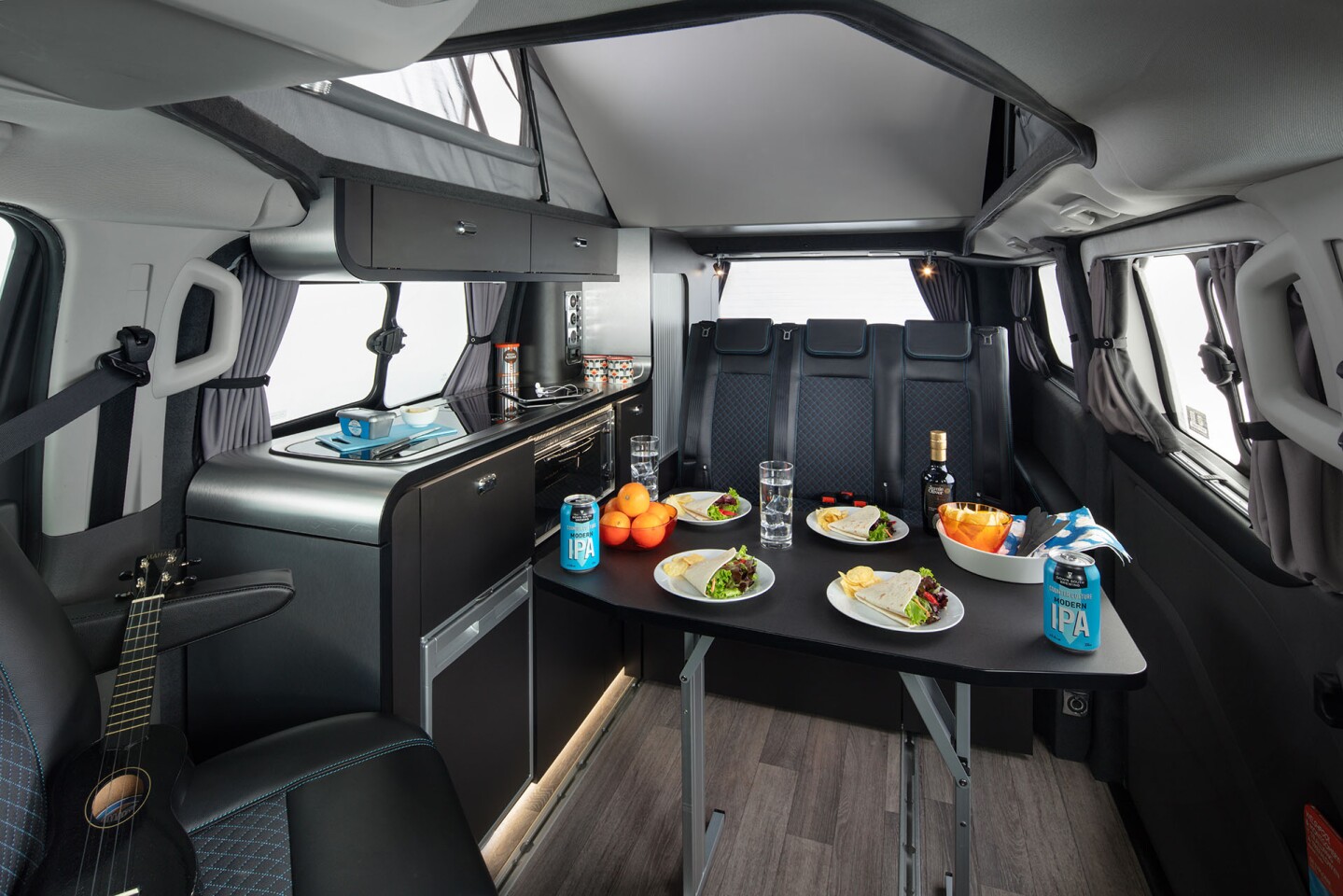 The two-legged removable table appears larger than the tables in many small camper vans, offering space for everyone to dine together