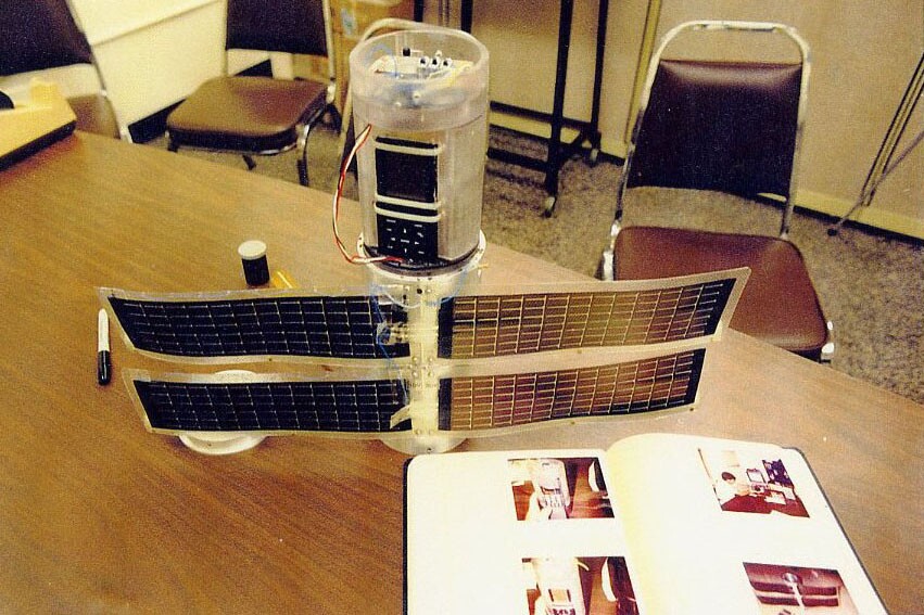 This rugged satellite, made from off-the-shelf parts, was test-fired at 3,200 G, prepared "using good mechanical design and a small amount of epoxy." Features include a camera, GPS, communications, solar cells and a battery power supply. It remains fully functional.