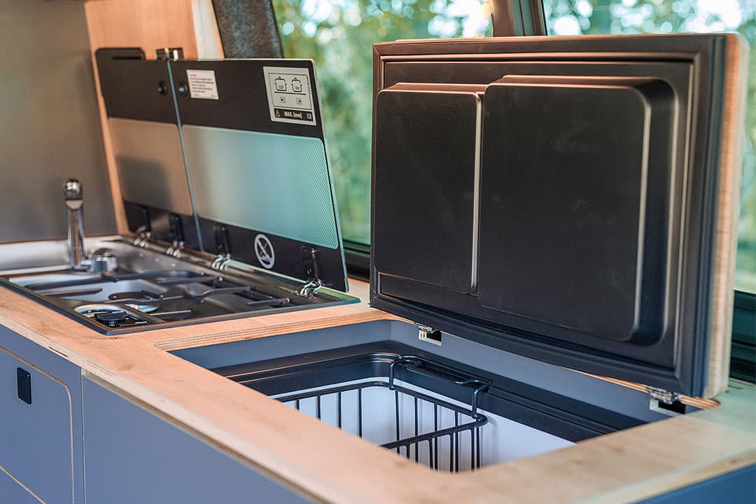 The Ultimate camper kitchen includes a sink/stove combo and fridge box that close to create a worktop