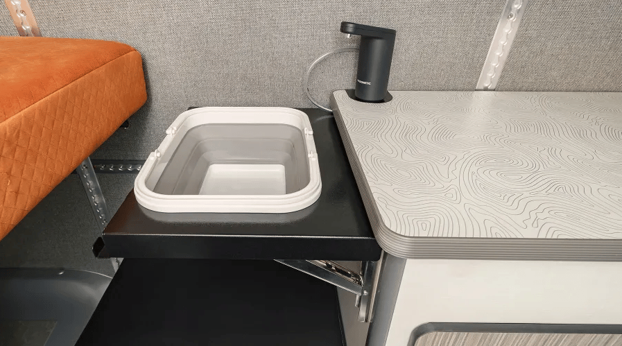 The Winnebago + Adventure Wagon camper van uses a modular sink with flip-up collapsible basin, Dometic HYD-WF magnetic faucet and HYD-J11 water canister