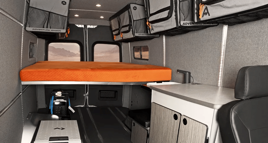 The Winnebago + Adventure Wagon camper van's high bed mounts over top the EcoFlow power station and cargo