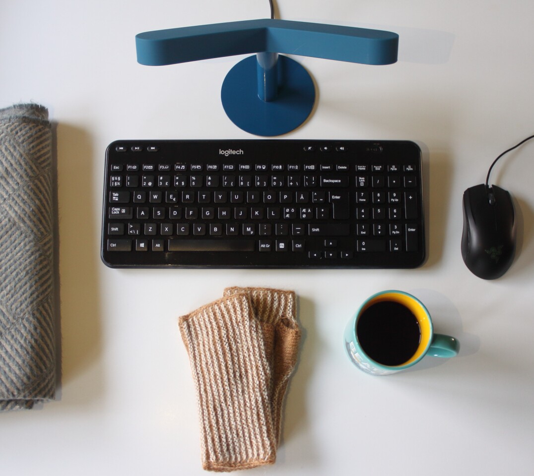 The Varme hand heater is positioned between a monitor and keyboard to keep typing hands warm