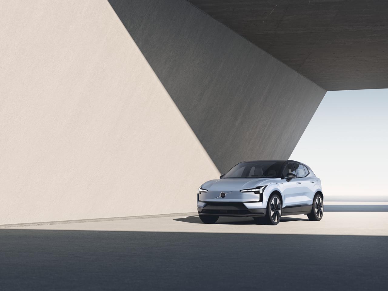 The Volvo EX30 has digital Thor's hammer headlights, a body-color grille area, and a lower fascia/front bumper design distinct from the EX90