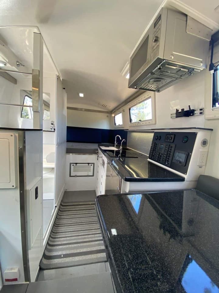 The FX floor plan has the bathroom inside the doorway across from the kitchen, a rear raised bed and a front convertible dinette