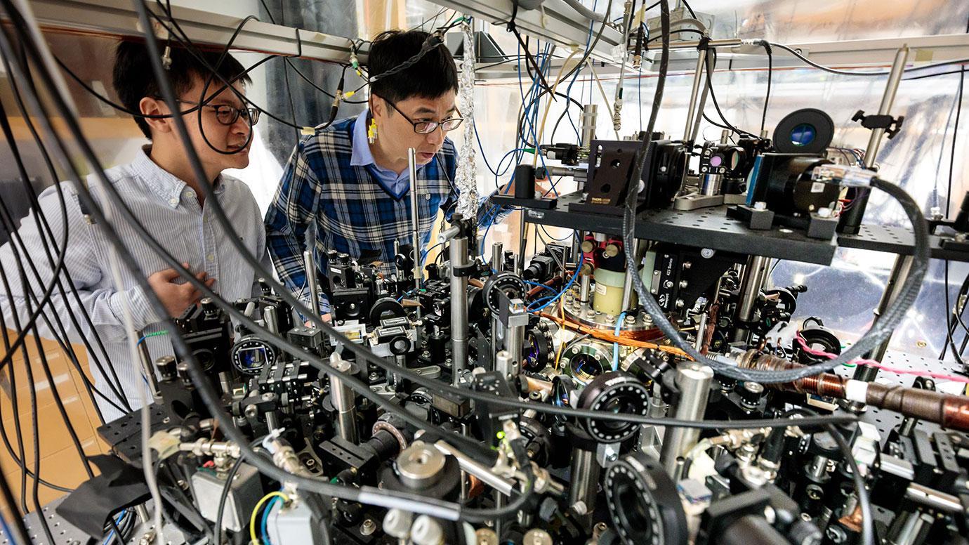Co-authors Zhendong Zhang (left) and Professor Cheng Chin with lab equipment that helped them observe quantum superchemistry for the first time