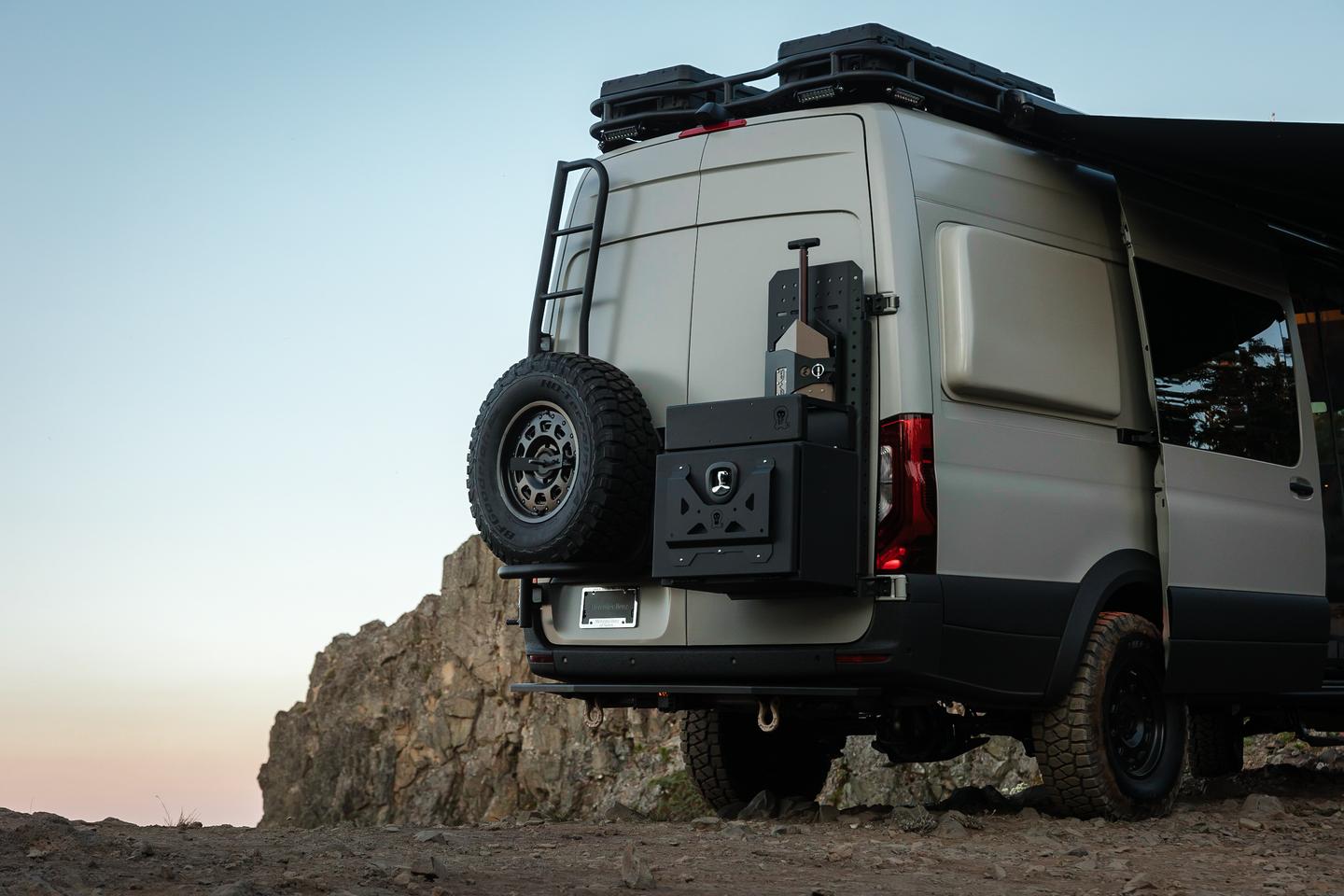 Owl Vans supplies the tire rack/ladder on the driver's side and the storage rack/box on the passenger's side; also note the Flarespace flare popping out to add sleeping space