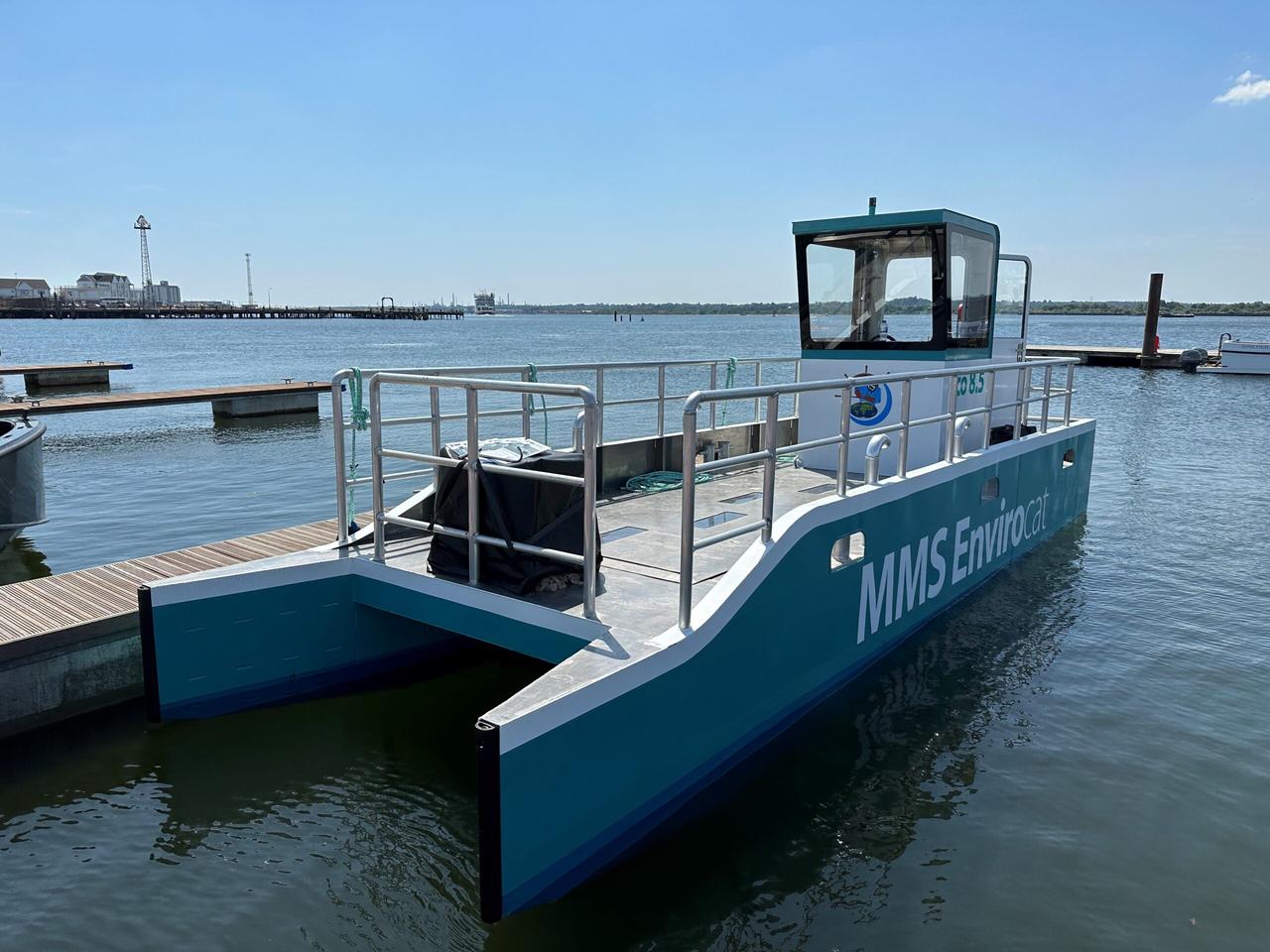 As floating plastic and debris enter the jaws of the catamaran, their progress is halted by a removable basket trap