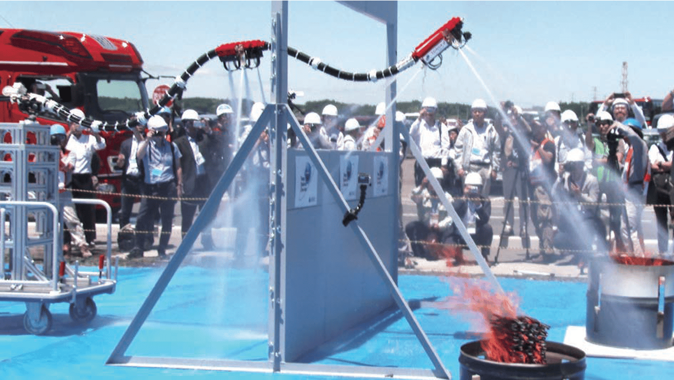 The robot flies over a wall to shoot water at some test barrels.