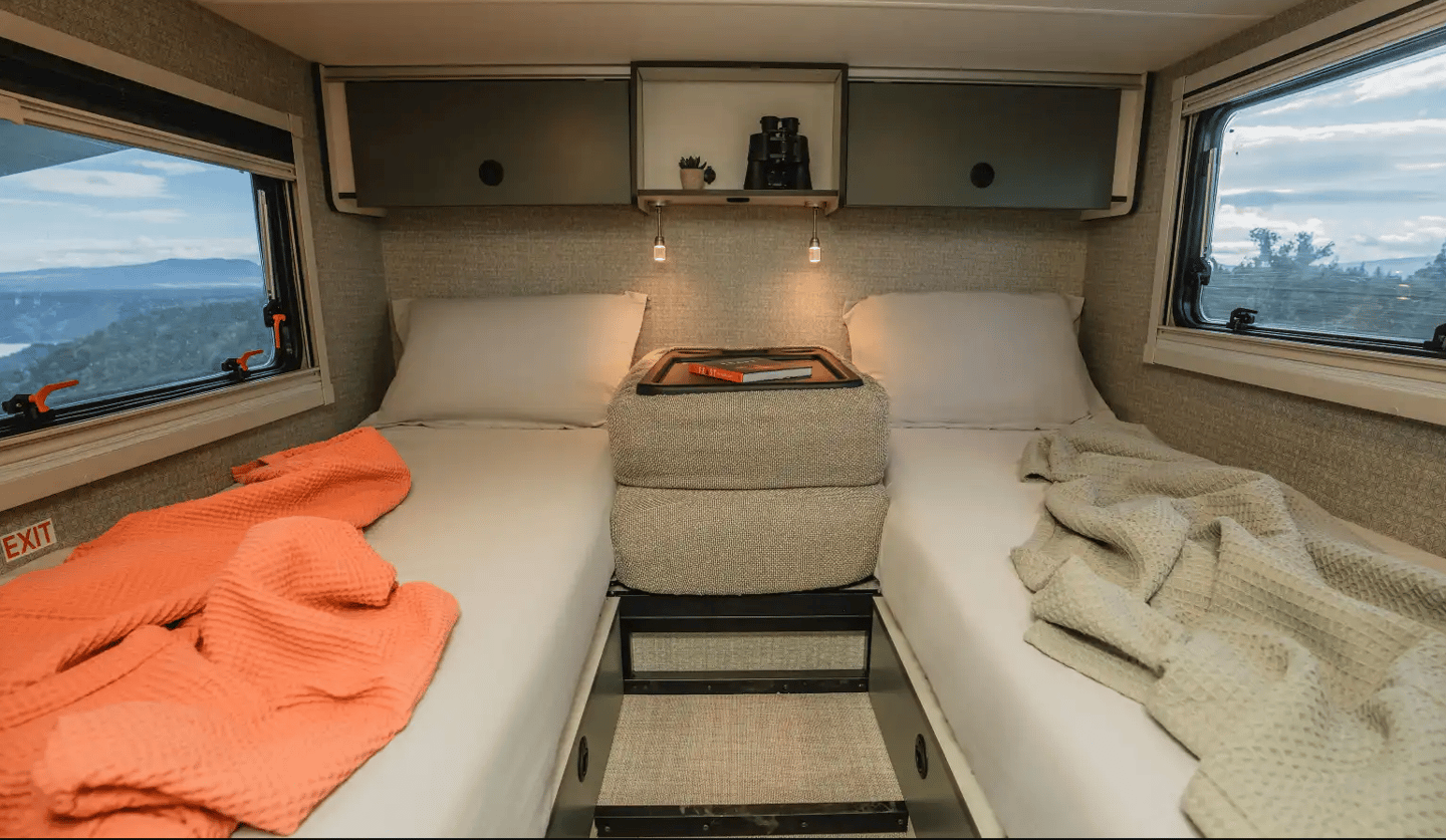 The bedroom area features two single beds that can convert into a double