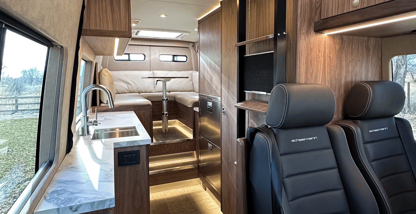 The interior features wood veneers throughout with foam-core construction for weight savings, porcelain countertops, a large rear lounge layout, and a combination of ambient and direct lighting with multicolor capabilities