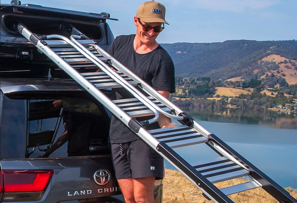 Pulling the height-adjustable folded ladder out of its storage compartment