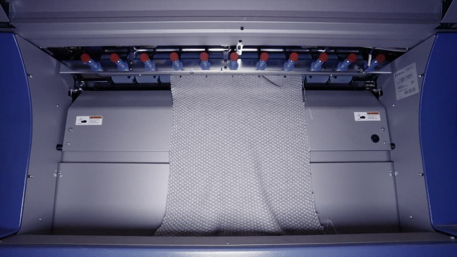 A complete 4D Knit Dress comes out of a Stoll industrial knitting machine after being produced in one piece