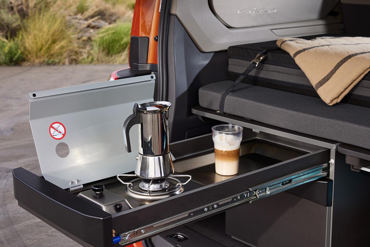 No more hideaway door kitchen – the new California Beach Camper uses a slide-out tailgate kitchen with single-burner stove