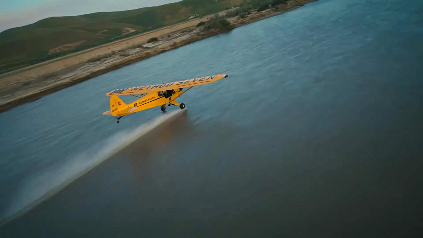 Eric Tucker wheel-taps the river below him in his Piper J3 Cub