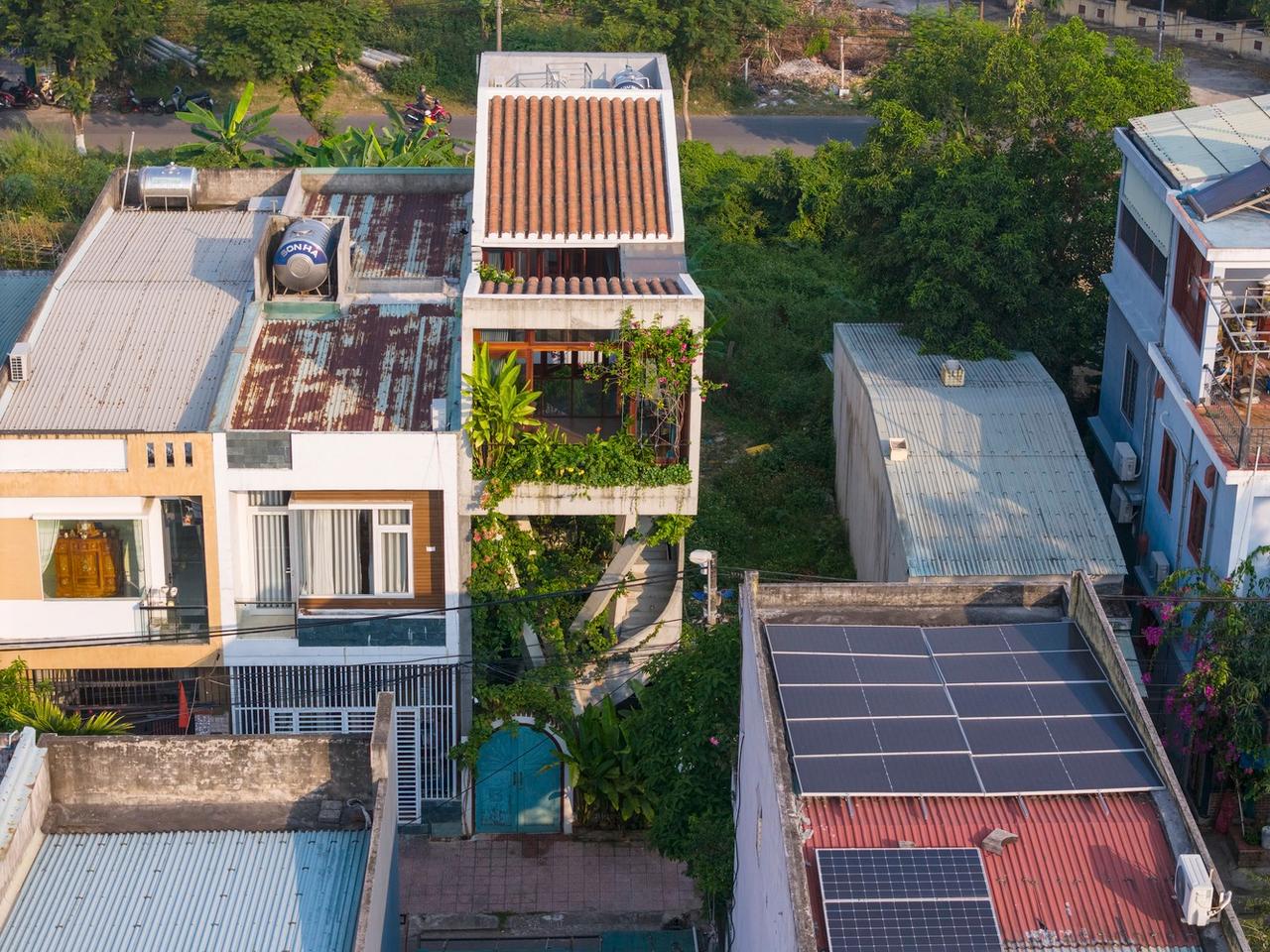 Elevated on x-shaped pillars, the three-story structure appears to float above its landscape
