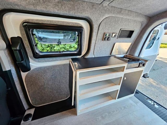 No sink, but Alpincamper's tiny kitchenette does include a stove, extendable worktop and a fridge across the way