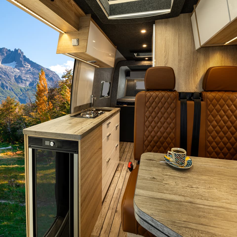 The food prep area includes a wooden worktop, dual-burner stove, small sink and fridge