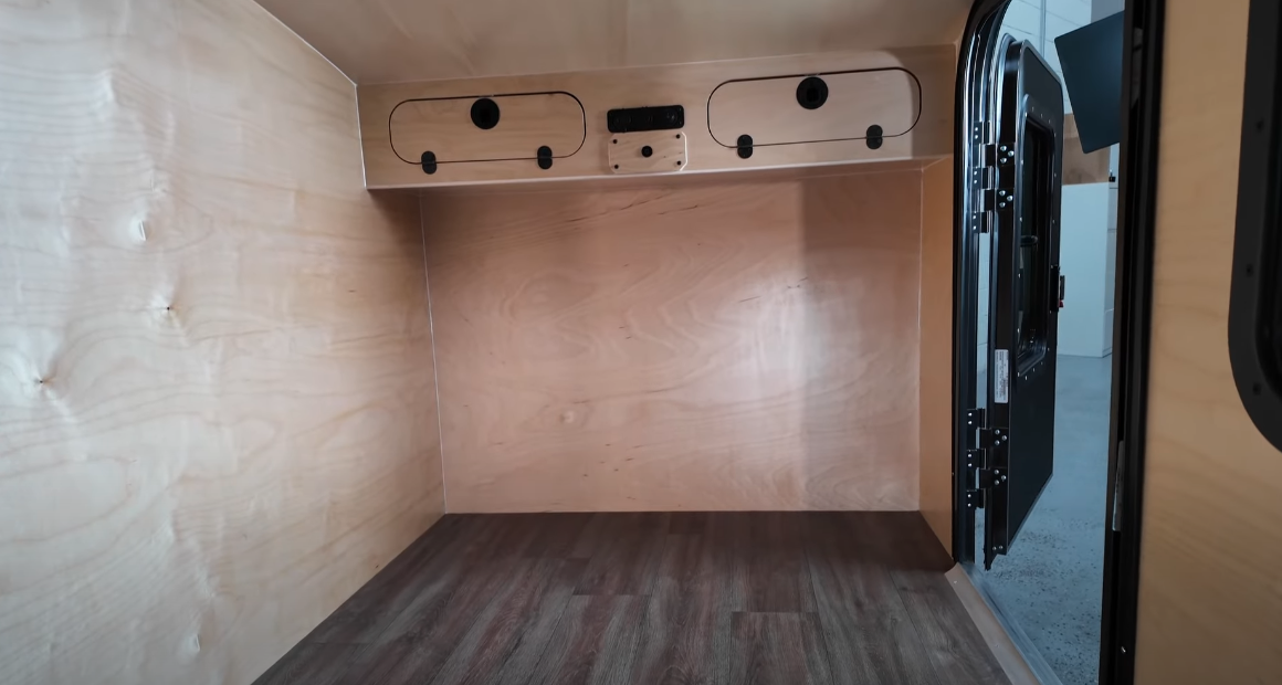 The front-end of the interior includes upper cabinets for a little bit of storage; the mattress is not included