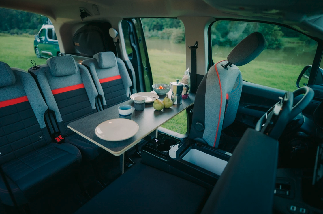 Indoor dining with the multipurpose tabletop - the passenger-side front seat folds down and sets up as a vis-a-vis seat using the bed cushions