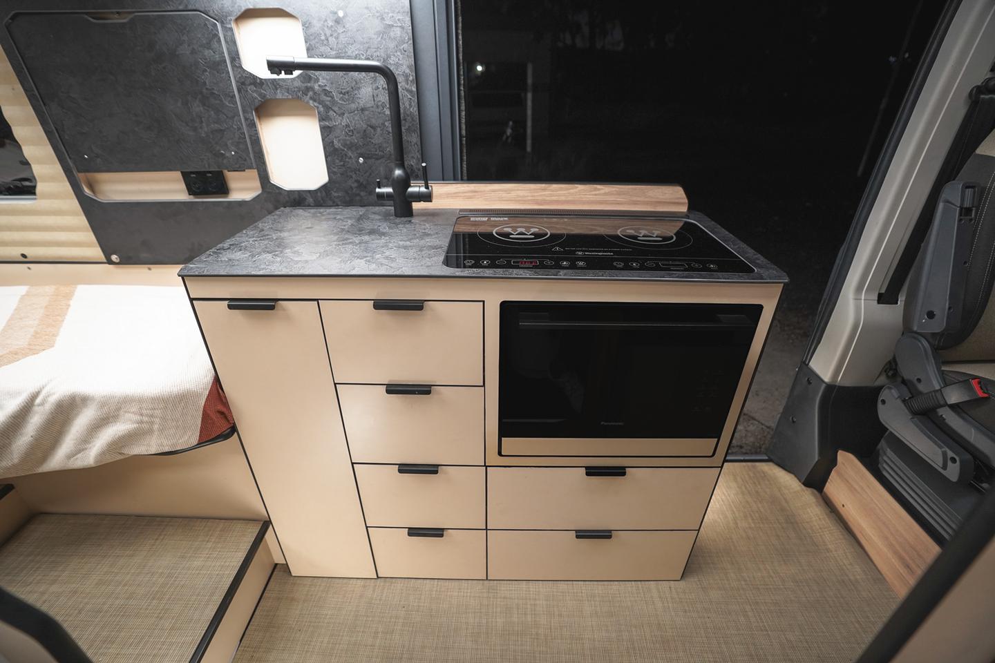 Kitchen block with dual-burner induction cooktop and microwave oven