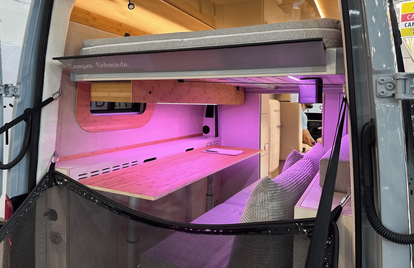 The bed slides up and down electrically into different positions above the lower workspace/sofa lounge