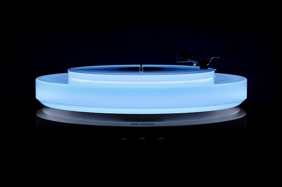 The Hotaru turntable appears to float above its speaker-packing base