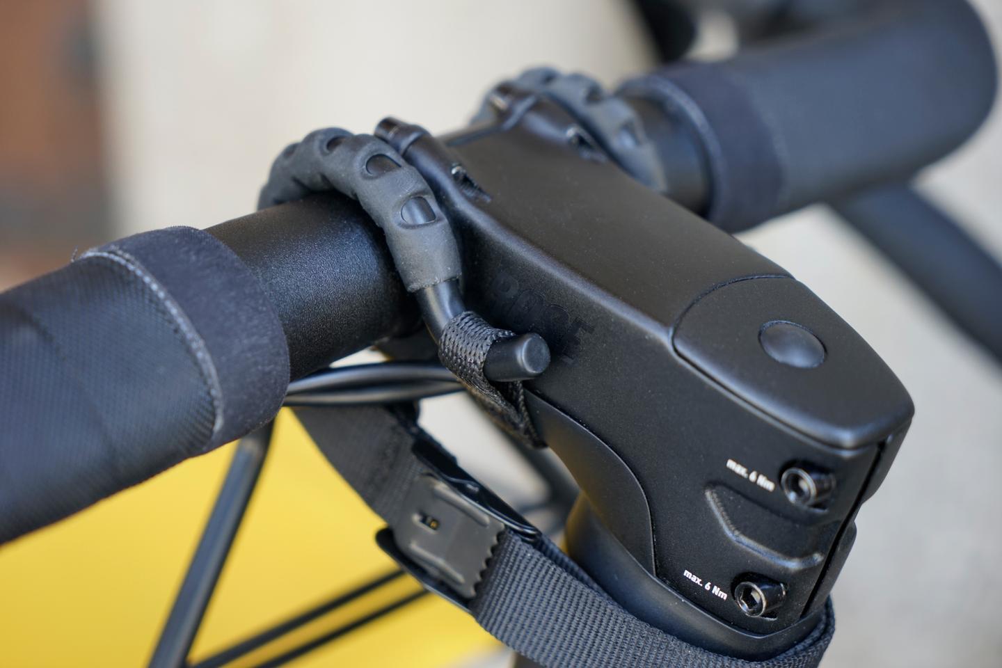 A close look at the rack's attachment mechanism, with one strap going beneath the stem and another going around the steerer