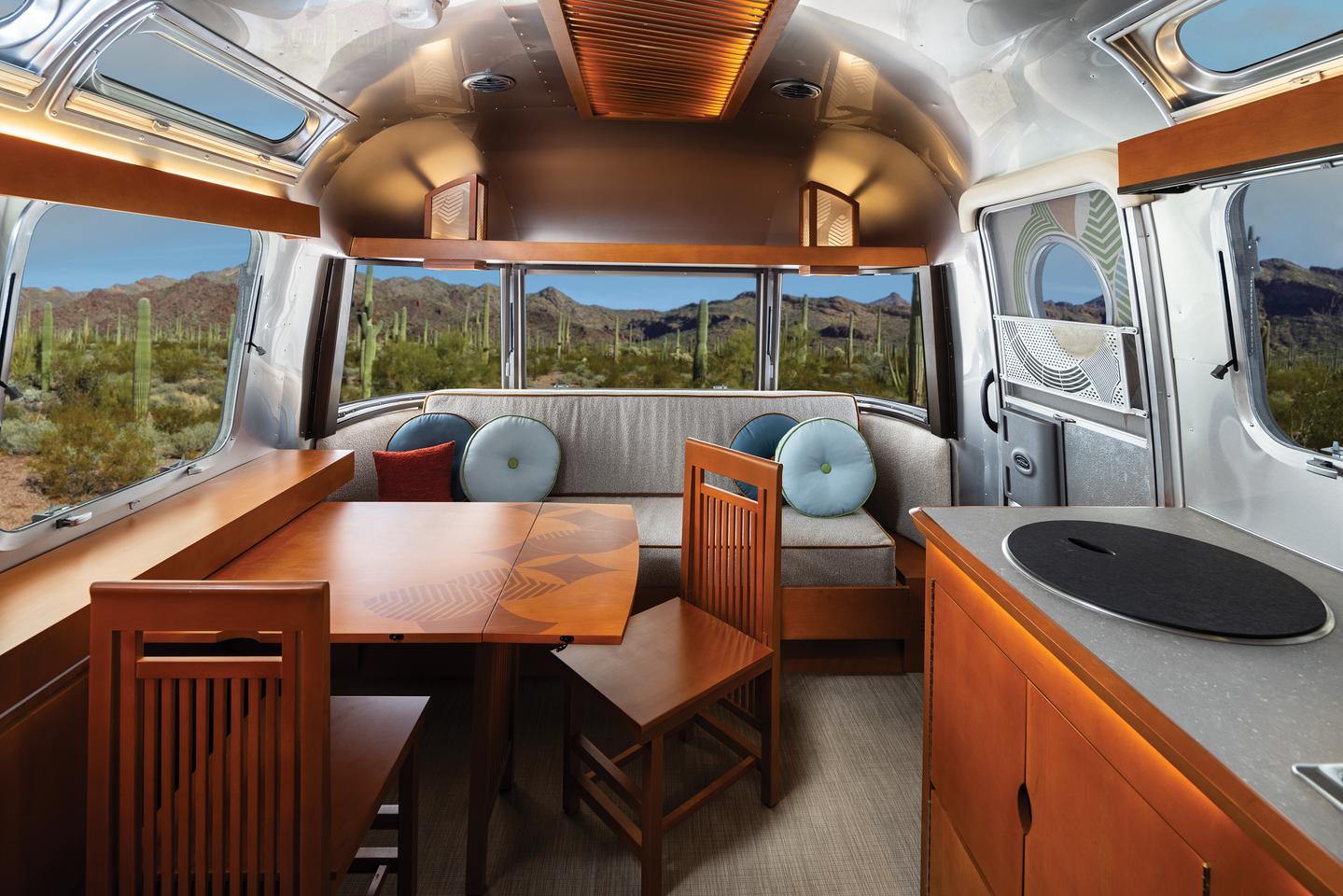 The dining table serves as the front face panel of the side console, swinging up to seat four for dinner